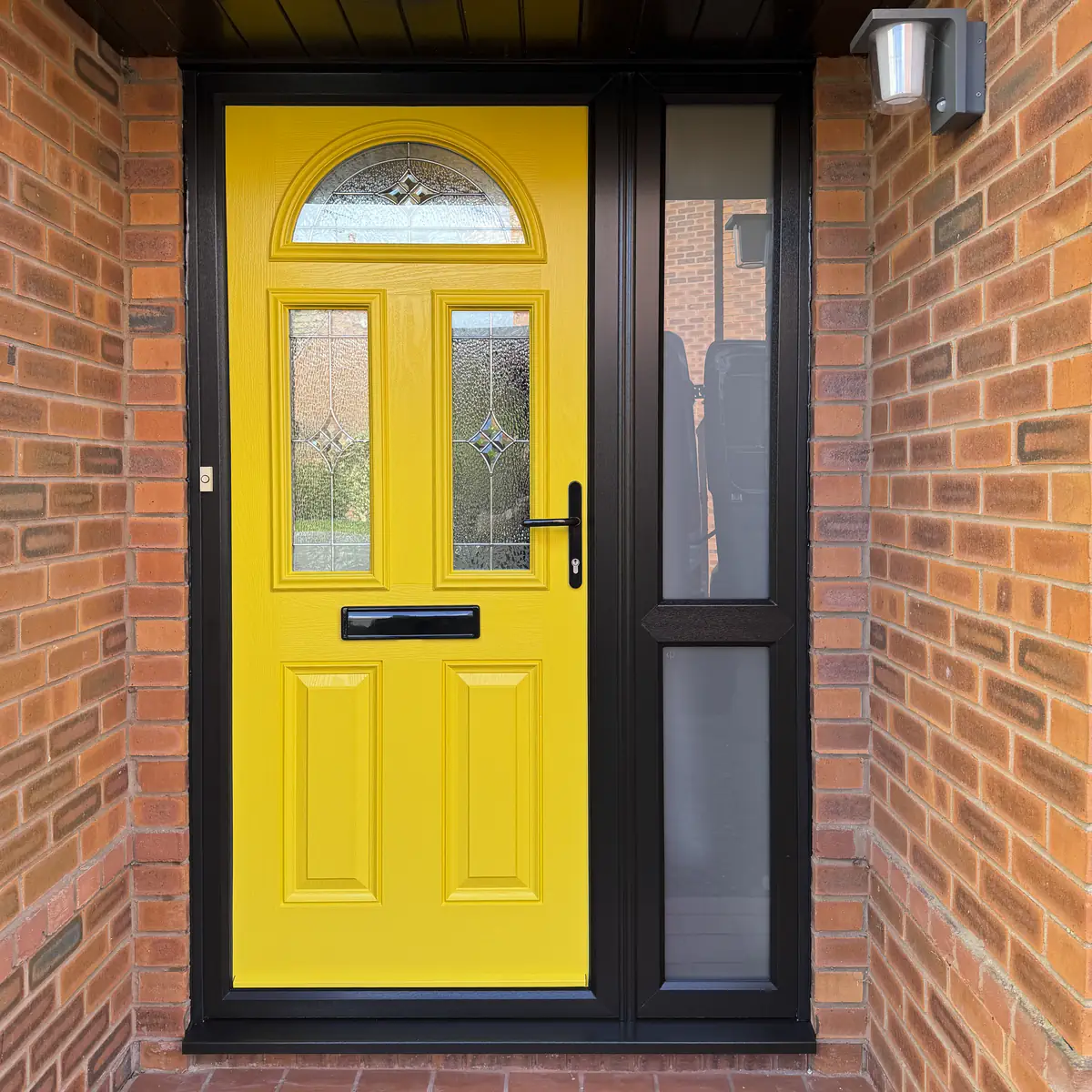 Yellow composite front door with side panel and black external frame