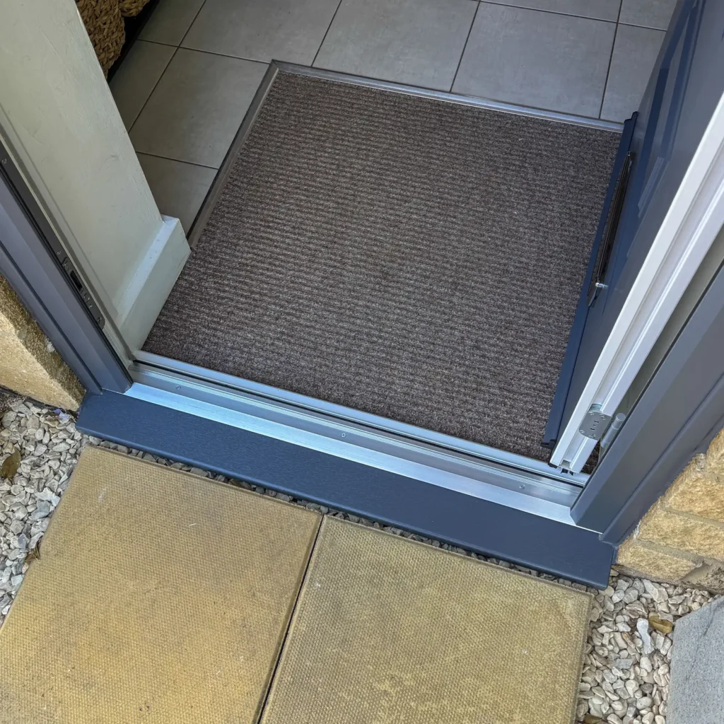 Photo of a Rockdoor Low aluminium opening in threshold in silver sitting on an Anthracite Grey 150mm cill, fitted by Jim and Josh