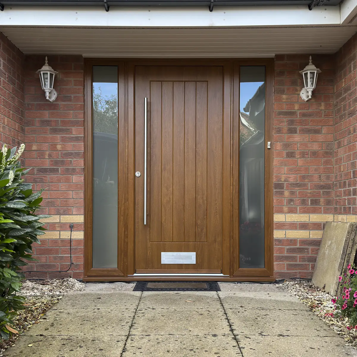 Light oak composite front door with matching frame, long bar handle and side panels